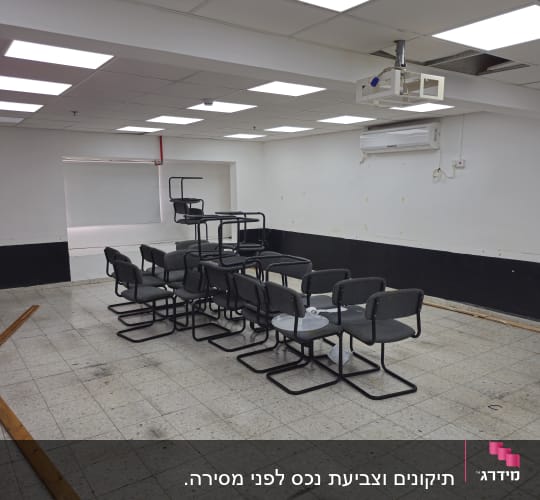 חדר עם כיסאות מוערמים, קירות צבועים ותקרה מוארת